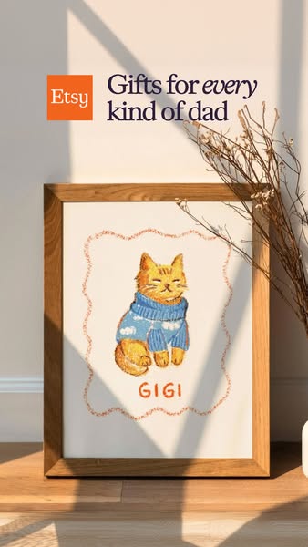 This ad from Etsy promotes gifts for every kind of dad with an image of framed wall art featuring a drawing of a cat wea