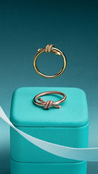 This ad showcases the Tiffany Knot ring. The image features two rings, a gold one at the top and a rose gold one on a Ti