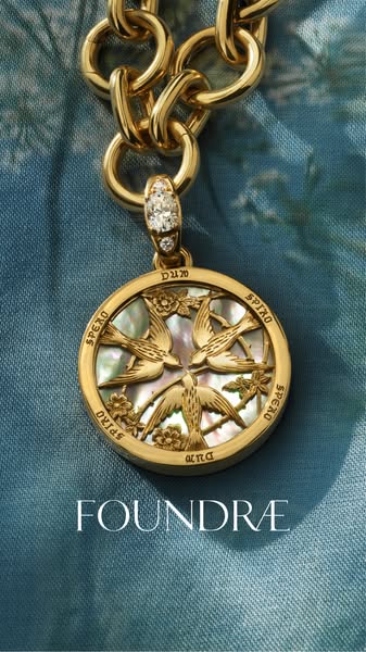 This ad showcases a gold necklace with a circular pendant from Foundrae. The pendant features a design with birds and fl