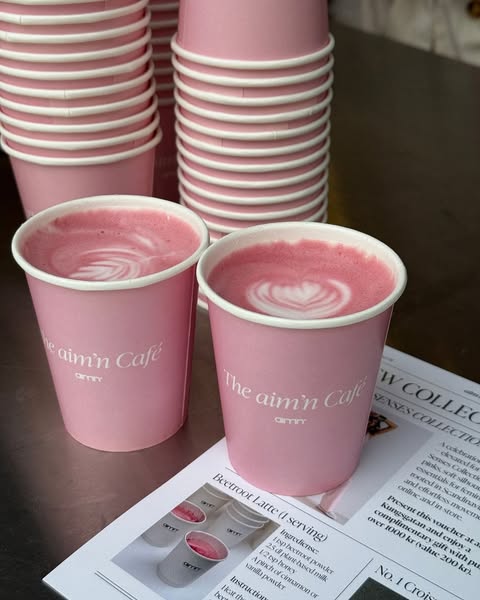 This ad promotes the Aim'n Cafe Beetroot Latte. The ad features two pink paper cups filled with Beetroot Latte with 