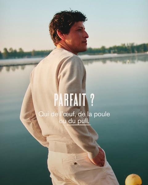 This image ad features a man wearing a light-colored sweater and pants, standing in front of a body of water. The ad use