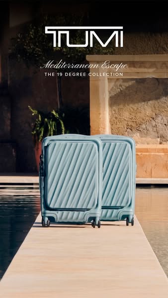 This ad showcases two light blue Tumi brand carry-on suitcases. The suitcases are presented on a light tan walkway, with