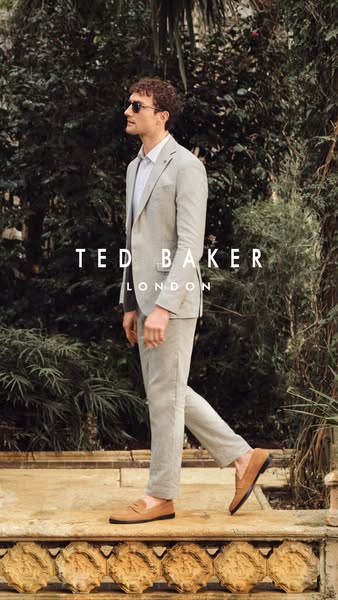 This ad features a man walking and wearing a light colored suit and brown loafers from Ted Baker London. The image is se