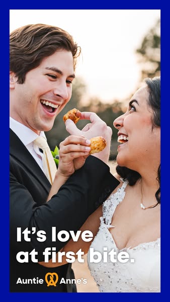 This image ad showcases a happy couple on their wedding day sharing an Auntie Anne's pretzel bite. The ad associates