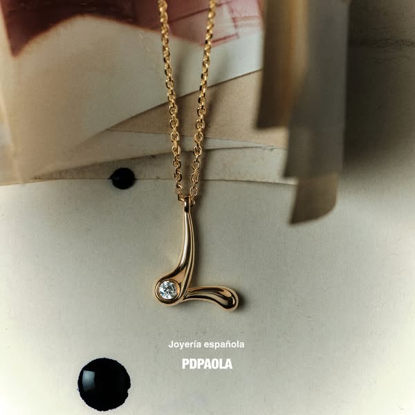 This ad showcases a gold necklace from PDPAOLA in front of a blurred background, highlighting the brand's Spanish or