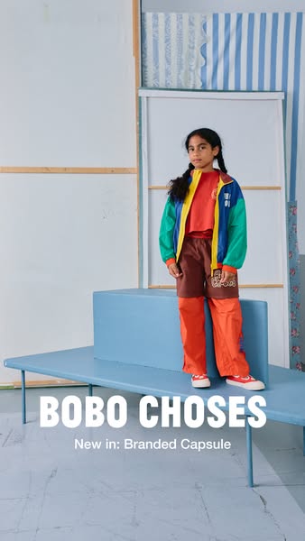 This ad showcases a young girl modeling a colorful jacket and pants set from Bobo Choses' new branded capsule.