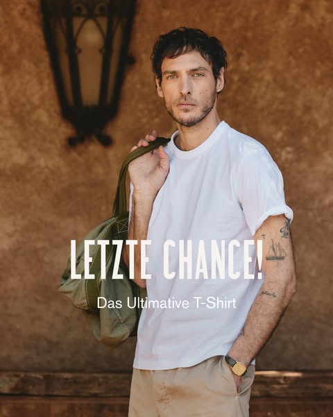 A male model stands in front of a building wearing a white t-shirt with a canvas bag over his shoulder. Copy reads, &quo