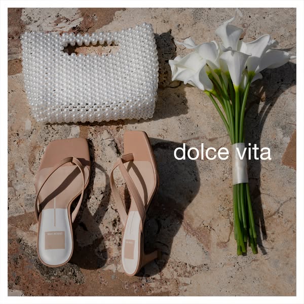 This image showcases a pair of Dolce Vita heeled sandals paired with a handbag and flowers.