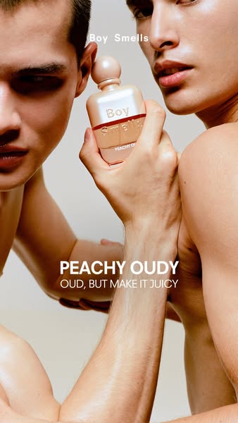 This ad features a close-up shot of two shirtless men, one holding a bottle of Boy Smells Peachy Oud fragrance. The ad e