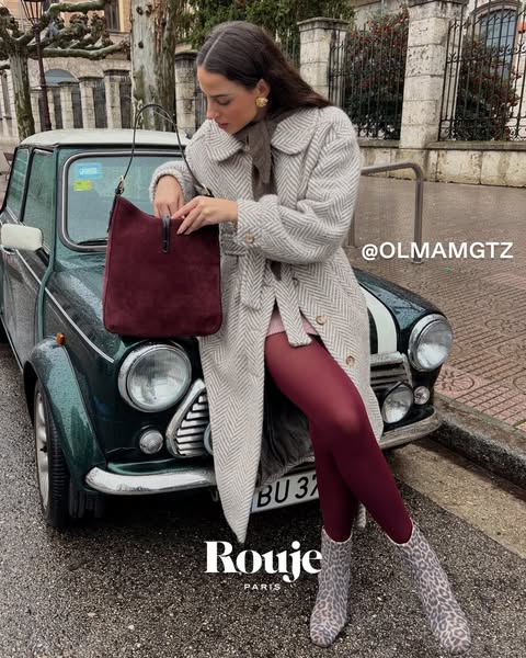 This ad showcases a Rouje handbag in a lifestyle setting, featuring a woman with a vintage car. The ad aims to highlight