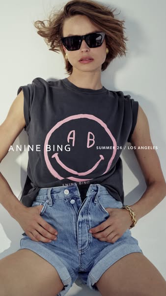 This image ad for Anine Bing features a model wearing the brand's clothing, including a graphic t-shirt and denim sh