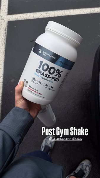 A first-person shot of someone holding a container of Transparent Labs 100% Grass-Fed Whey Protein Isolate and the words