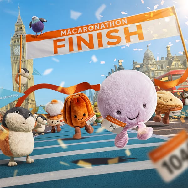 An image showing a group of Jellycat stuffed food with faces running a marathon in London. The ad implies that the brand