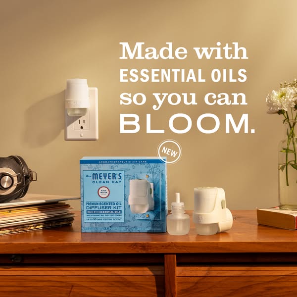 This image ad promotes Mrs. Meyer's Clean Day Premium Scented Oil Diffuser Kit, emphasizing its use of essential oil