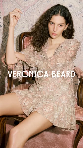 This image ad showcases a woman wearing a Veronica Beard dress in a lifestyle setting. The ad focuses on the brand's