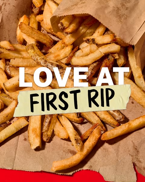 This image ad features a close-up of Five Guys fries spilling out of a brown paper bag, with the text "LOVE AT FIRS