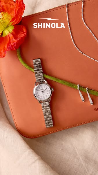 This ad showcases a woman's watch, a clutch, a necklace, and a pair of earrings from Shinola.