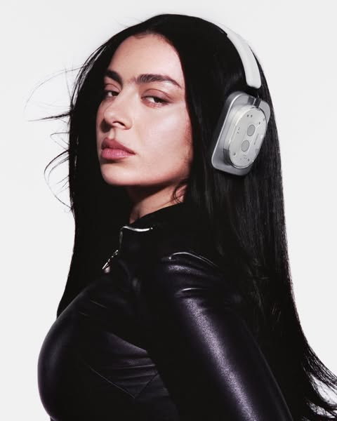 This ad features a close-up shot of a model wearing silver headphones, emphasizing their sleek design and fashion-forwar