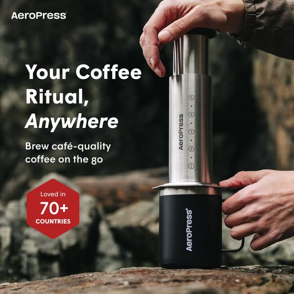 This image ad showcases the AeroPress coffee maker being used outdoors. The ad highlights the coffee maker's portabi