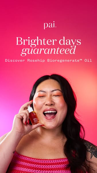 This ad features a woman holding up a Pai Rosehip Bioregenerate Oil bottle. She's smiling in front of a pink gradien