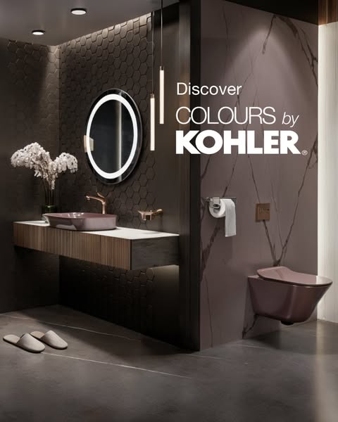 A modern bathroom is shown with the focal point being a wall mounted toilet and sink in a muted mauve color. The ad is m