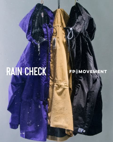 A product image ad demonstrating the water resistance of the FP Movement rain jacket. The ad features three rain jackets