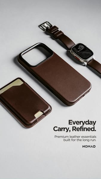 The ad features a minimalist arrangement of everyday carry essentials, including a brown leather phone case, a leather w