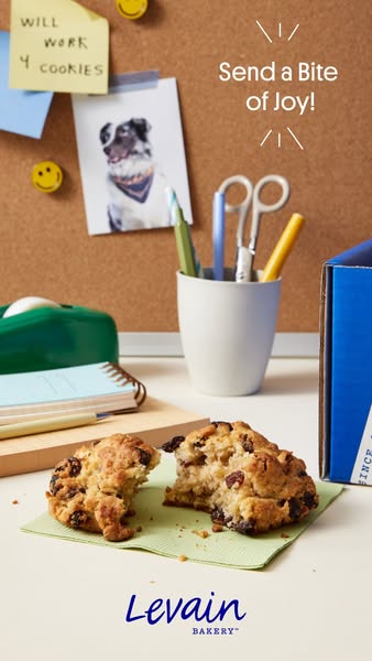 An advertisement for Levain Bakery cookies. The image shows a cookie that has been broken in half on a light green napki
