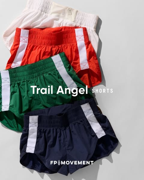 This ad promotes FP Movement Trail Angel shorts by showing a stack of the shorts in different colors on a neutral surfac