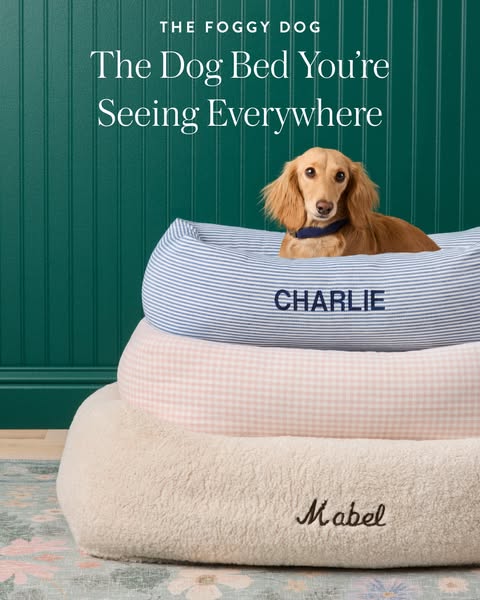 This ad for The Foggy Dog shows a stack of three dog beds. The beds have different patterns and are each embroidered wit