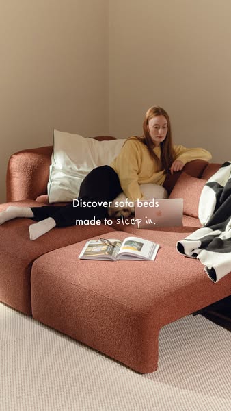 An image ad promoting sofa beds, featuring a woman relaxing on a sofa bed with a laptop and a book.