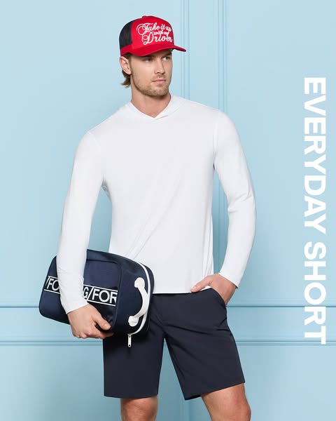 This ad shows a model wearing navy shorts and a white, long-sleeved shirt. He is also carrying a navy blue bag that has 