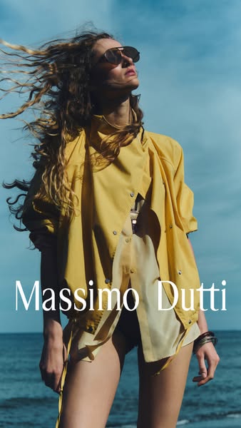 An image ad from Massimo Dutti featuring a woman posing on a rocky beach wearing the brand's clothing. The ad has a 