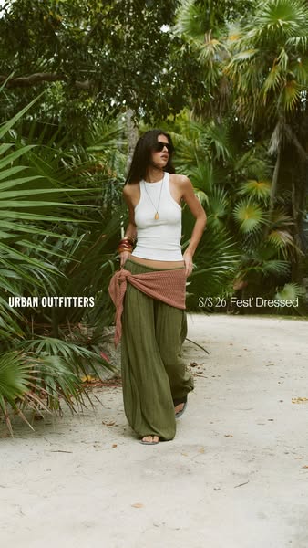 An image ad showcases Urban Outfitters' clothing, specifically highlighting a ribbed white tank top and flowing gree