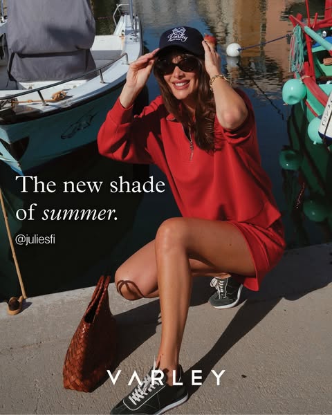 This ad features a lifestyle shot of a woman in a red matching outfit. She is accessorized with a baseball cap, sunglass