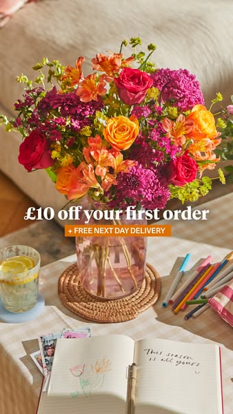 An image ad for a flower delivery service. The ad features a bouquet of flowers in a pink glass vase set on a table with