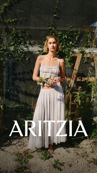This ad features a model wearing a matching top and skirt set from Aritzia. The setting is a greenhouse-type structure w