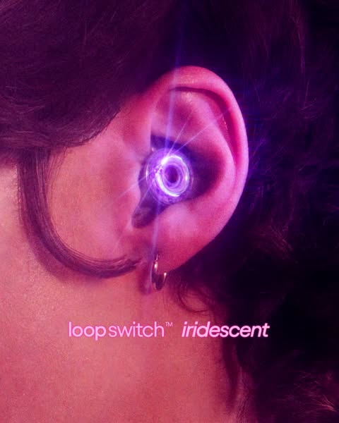 This ad shows a close up shot of a Loop Switch iridescent earplug in someone's ear. The image is pink and purple and