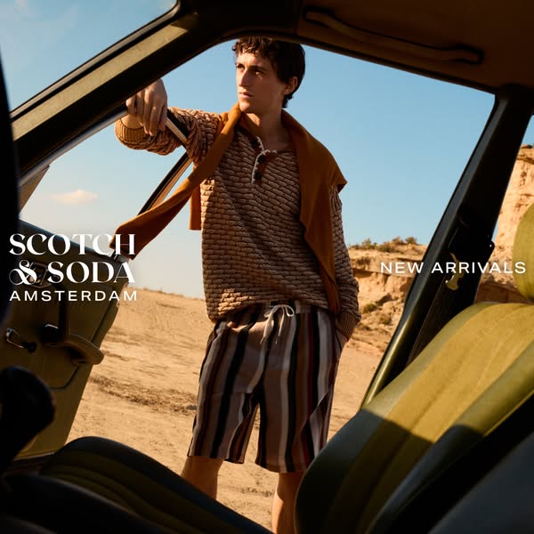 This image promotes Scotch & Soda's new arrivals by featuring a male model in desert attire, leaning out of a vi