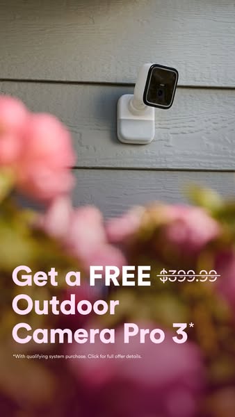 The image ad showcases the Outdoor Camera Pro 3, offered for free with a qualifying system purchase. The ad uses a visua