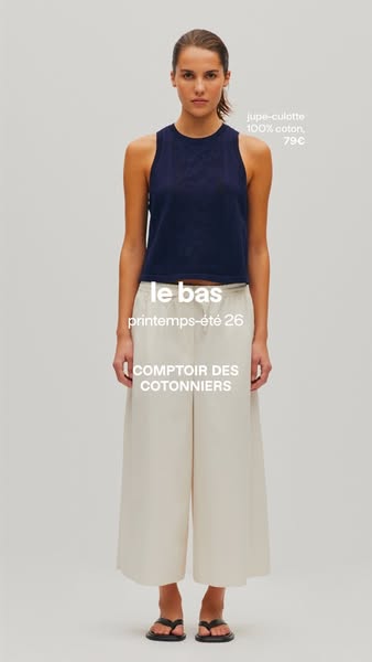 This ad features a woman showcasing a navy blue tank top and a pair of light-colored, wide-legged pants from Comptoir de