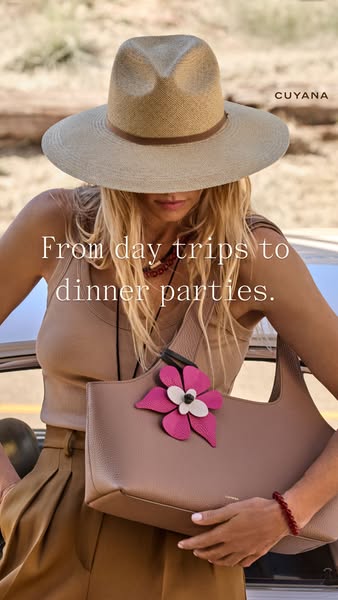 This ad for Cuyana features a woman in a straw hat standing outside with the leather tote bag slung over her shoulder. T