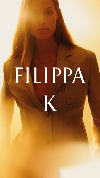 An image ad for Filippa K, featuring a model in a blazer or jacket, shot with bright lighting.