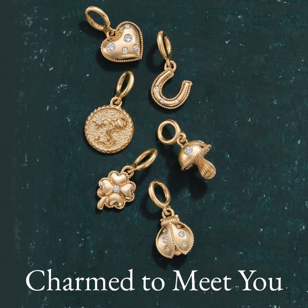This image ad features an array of charms on a textured surface while introducing the brand's new collection of char