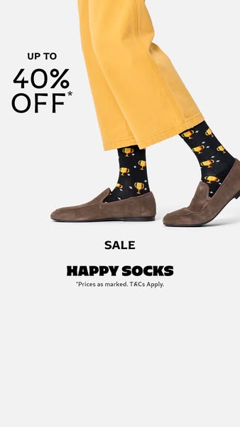 This image ad for Happy Socks features a person wearing a pair of black socks with a gold trophy pattern, paired with br