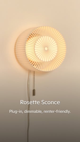 This ad showcases a Rosette Sconce wall lamp. The ad is targeted at renters, emphasizing the lamp's plug-in and dimm