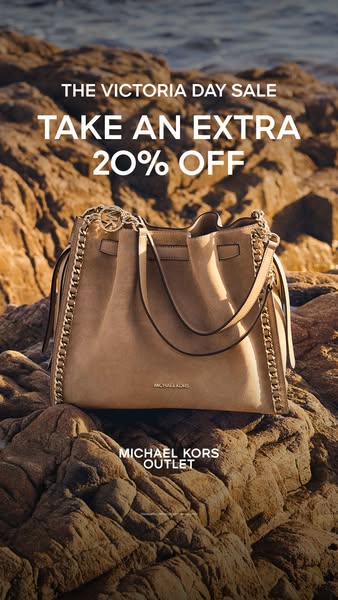 An image ad for Michael Kors Outlet promoting a Victoria Day sale with an extra 20% off. The ad features a beige handbag