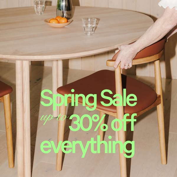 An image ad for a furniture company showing a light wood table and chairs set with a text overlay advertising a spring s