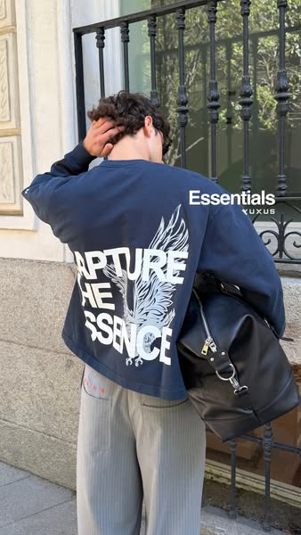 This ad features a person wearing a Essentials t-shirt. The shot focuses on the back of the shirt, highlighting its desi