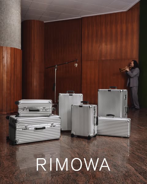This ad showcases Rimowa luggage in a setting that appears to be a studio or backstage area, featuring a musician playin